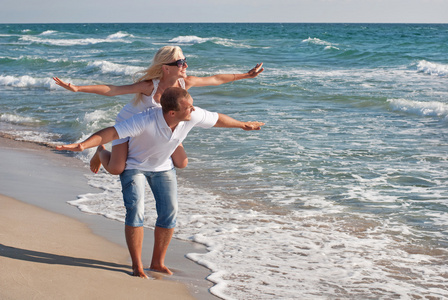 在夏天海沙滩上散步的恩爱夫妻图片