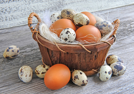 不同类型的在老木背景上篮子里的鸡蛋