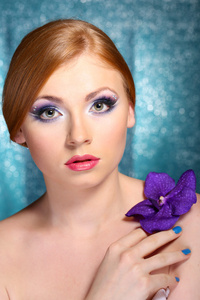 美丽的年轻女子，与魅力弥补和蓝色背景上的花