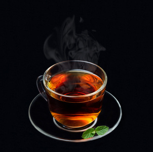 烟茶招牌杯红茶与薄荷和黑色背景上的烟照片