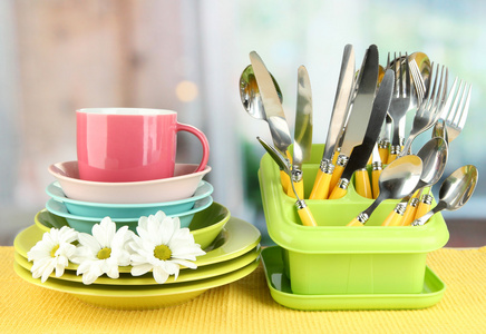 板 叉 刀 勺和其他厨房器具上彩色餐巾纸，在明亮的背景上