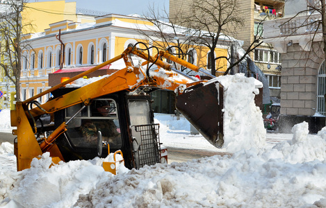 黄色拖拉机清洗街道上雪