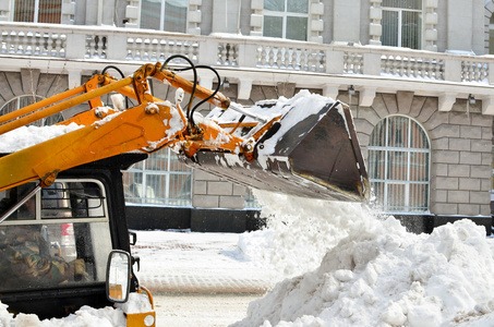 黄色拖拉机清洗街道上雪