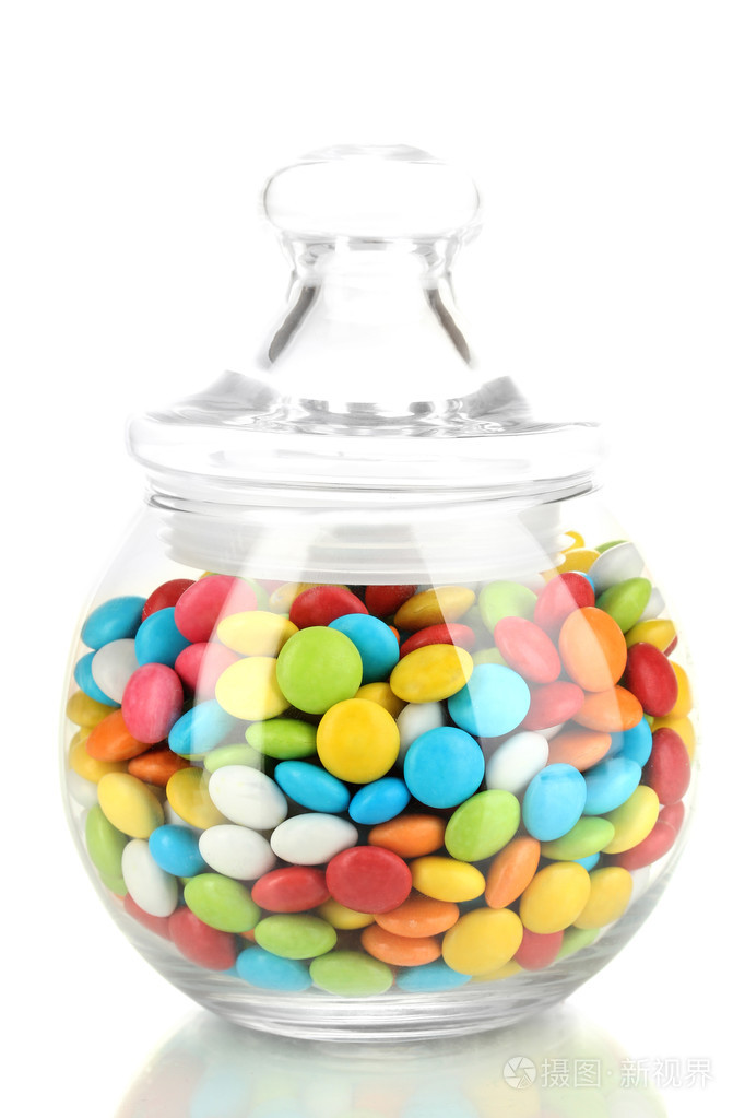 在白色上孤立的玻璃罐子里的多彩糖果