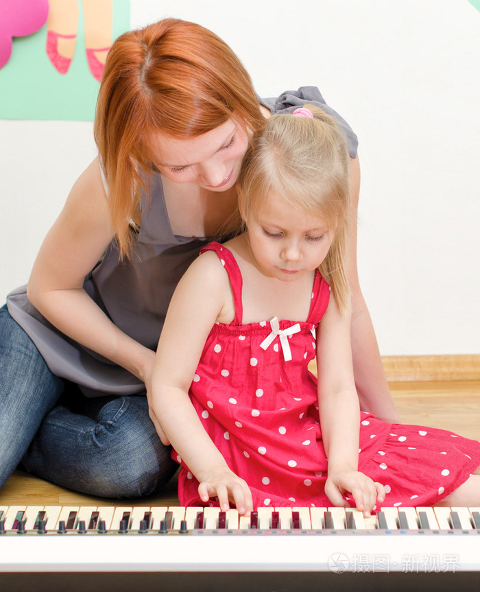 小女孩和她的母亲在弹钢琴
