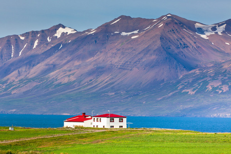 在海岸线北部冰岛的红色屋顶的白色壁板房子