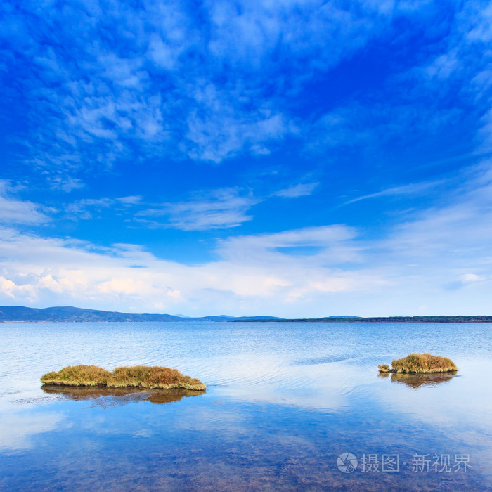 在下一个蓝色湖绿色的两个小岛的晴朗天空阿根塔里奥托斯卡纳意大利