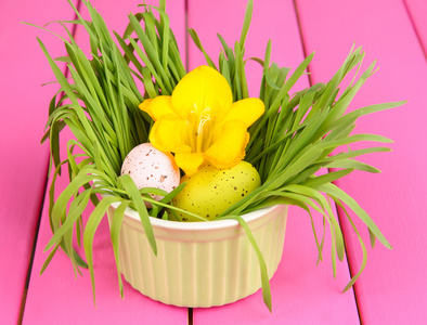 复活节彩蛋与草粉红色的木桌上的碗里关闭