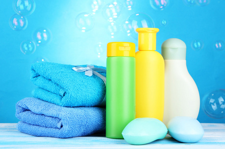 婴儿化妆品 毛巾和肥皂木桌，在蓝色背景上