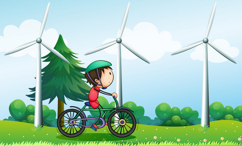 一个男孩与风车附近骑自行车骑