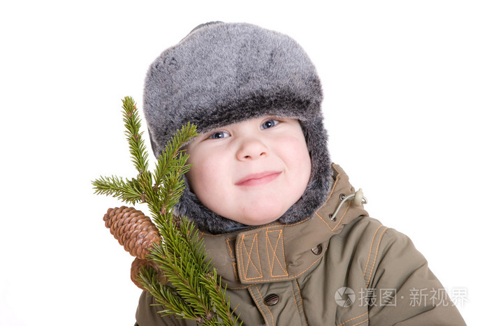 冬季大衣与皮草树的分支的男孩