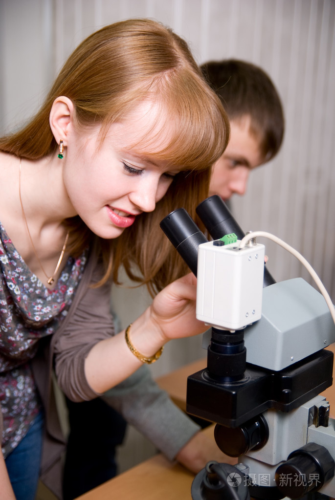 使用显微镜观察的女研究员