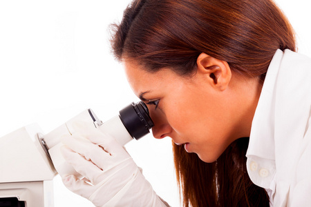 年轻的女研究员看着显微镜的特写