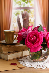 窗口背景上的木桌上花瓶里美丽的粉红色玫瑰