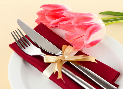 节日餐桌设置与米色背景上的郁金香