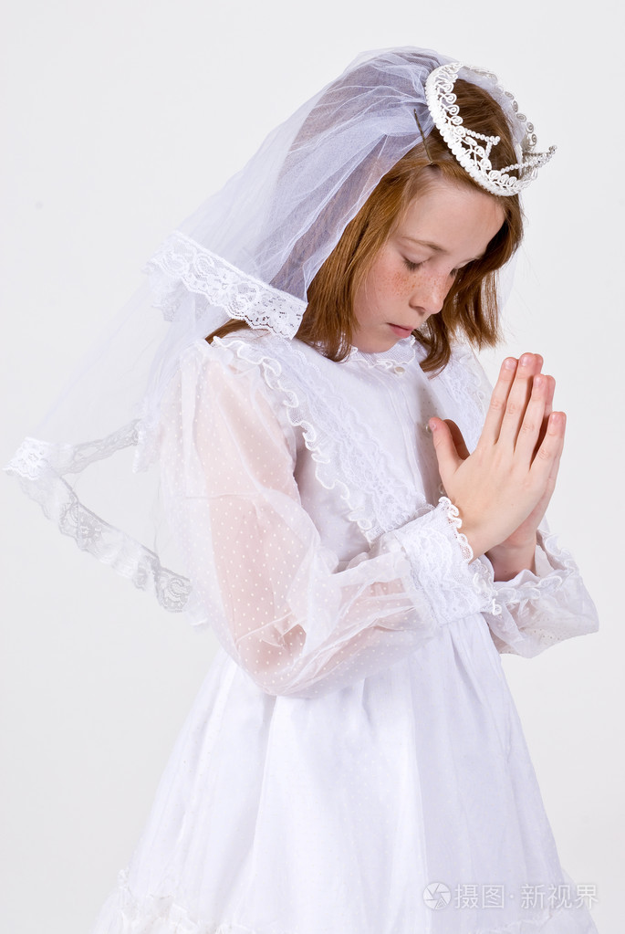 她第一次圣餐的年轻女孩打扮祈祷