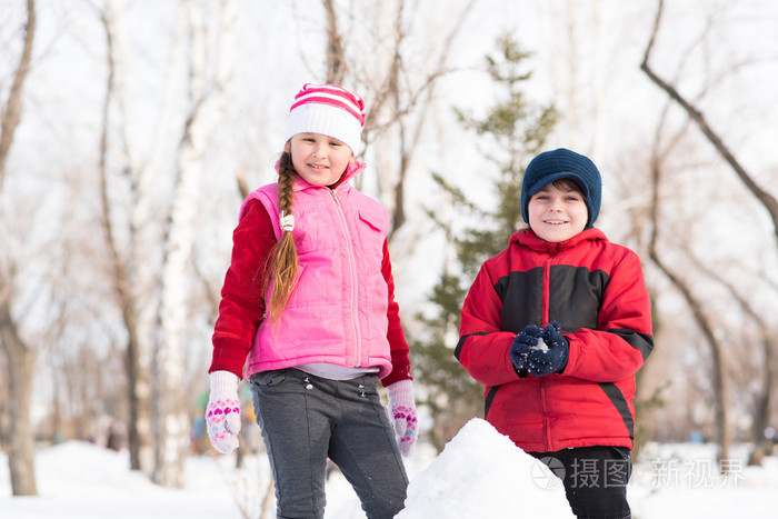 男孩和女孩玩雪的冬季公园