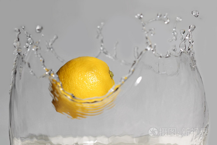 在白色背景上的柠檬溅入清水