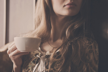 年轻漂亮的女孩与一杯茶