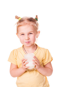漂亮的小女孩拿一杯新鲜的牛奶