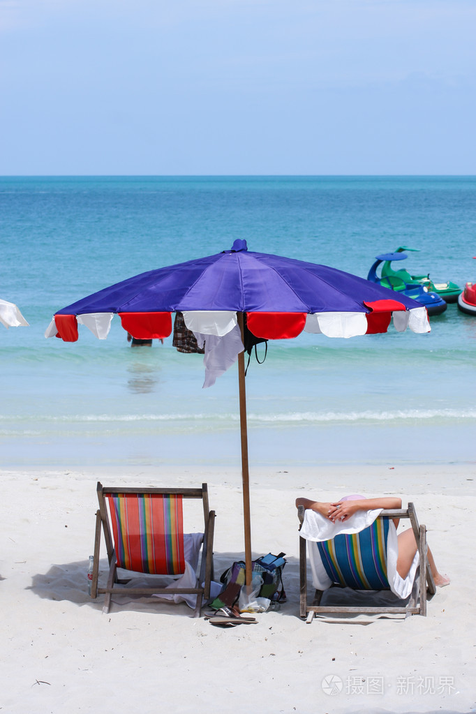 在热带海滩上的躺椅上的人