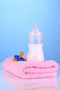 毛巾和在蓝色背景上的牛奶瓶