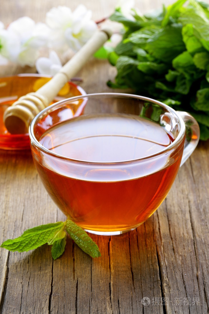 杯薄荷和木桌上的蜂蜜茶