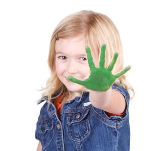 一个孩子与她手上的绿色环保涂料