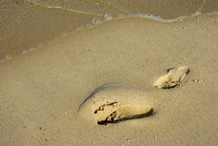 足迹的沙子和一波
