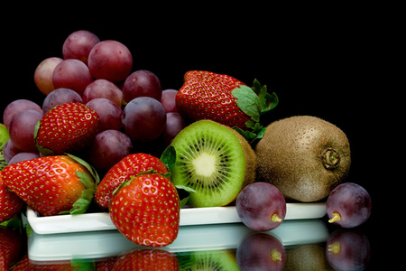黑色背景上的水果和浆果特写