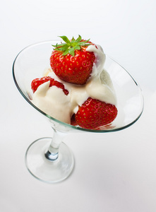 草莓和奶油在白色背景上的玻璃