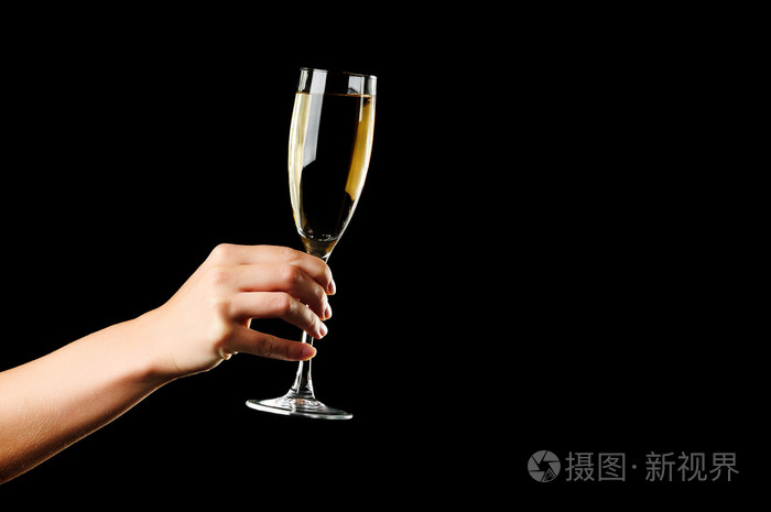 在黑色背景上孤立的女人手中的香槟杯