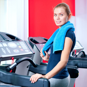 年轻女子在一台机器上运行的健身房