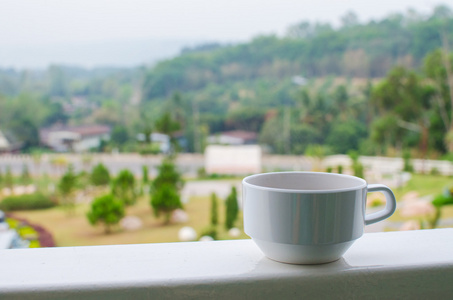 在与自然背景的阳台上一杯咖啡