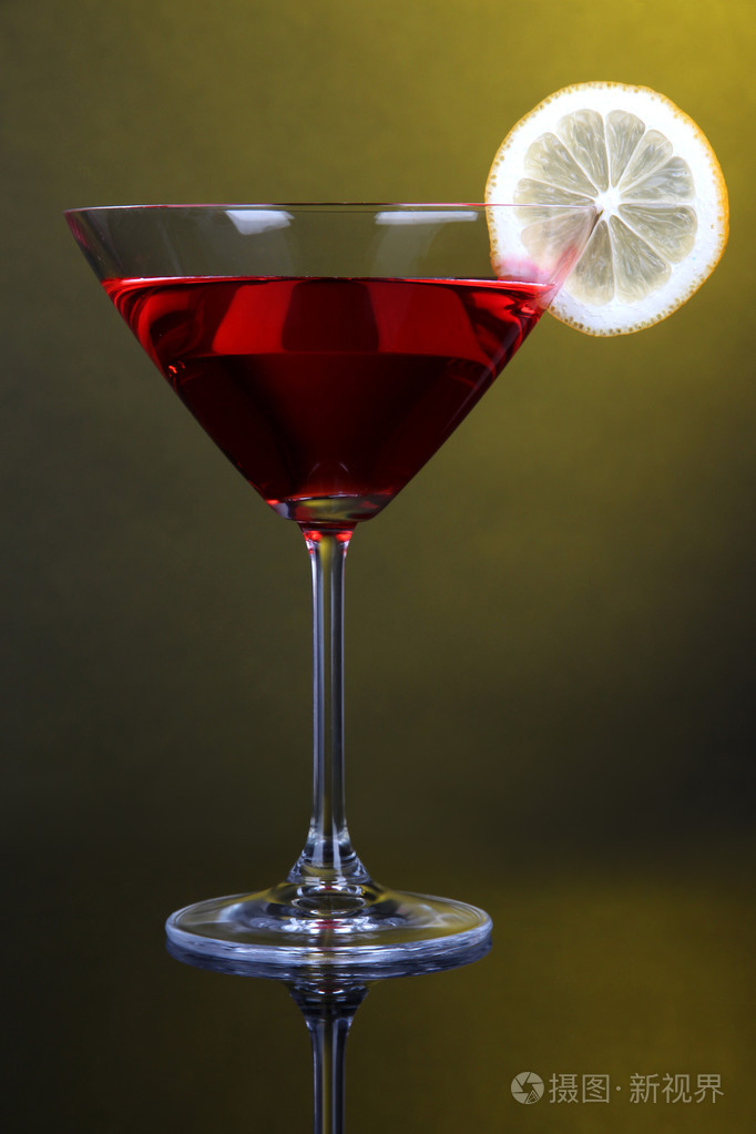 红色鸡尾酒马提尼酒杯上黑黄色的背景