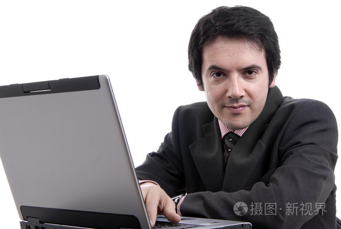 英俊的年轻商业男人工作用的笔记本电脑