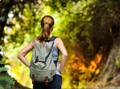 年轻女子背着背包徒步旅行照片