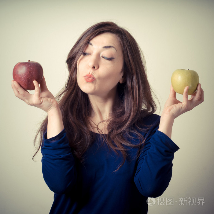 美丽的女人选择红色或黄色的苹果