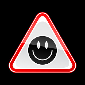 红色注意警告标志与黑色笑脸符号