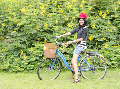 微笑女孩骑着自行车在公园里