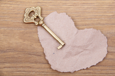 古色古香的密钥和心符号用纸做的木制背景上