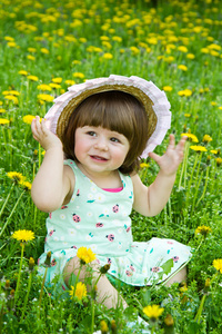 与白色的花在草原上的快乐女孩