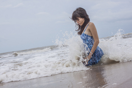 坐在野生海洋海滩的女模特