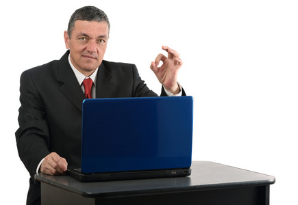 坐在桌前，用一台笔记本电脑上白色隔离岁的商人