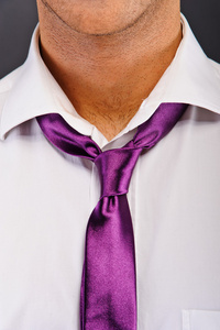 在黑暗的背景紫色领带的男人