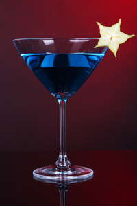 蓝色鸡尾酒马提尼酒杯上深红色背景