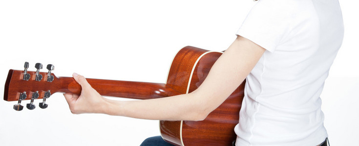 年轻的女人在吉他上打