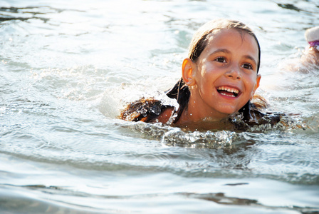 在水中游泳的快乐可爱的小女孩