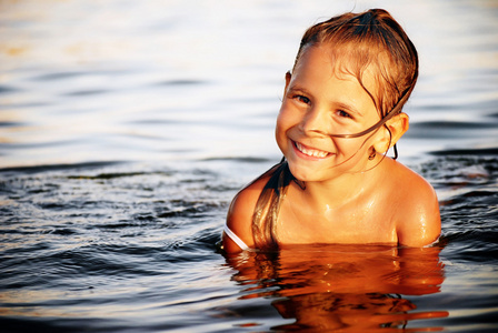 在水中游泳的快乐可爱的小女孩