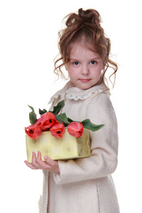 快乐的小女孩，在一件外套，拿一束郁金香和礼品盒